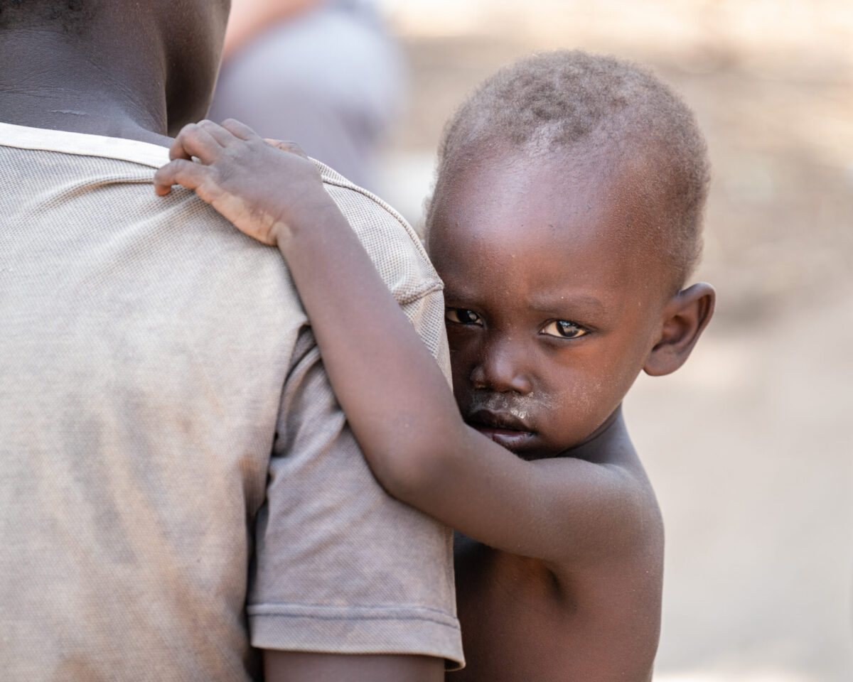 A boy looks over a man's shoulder