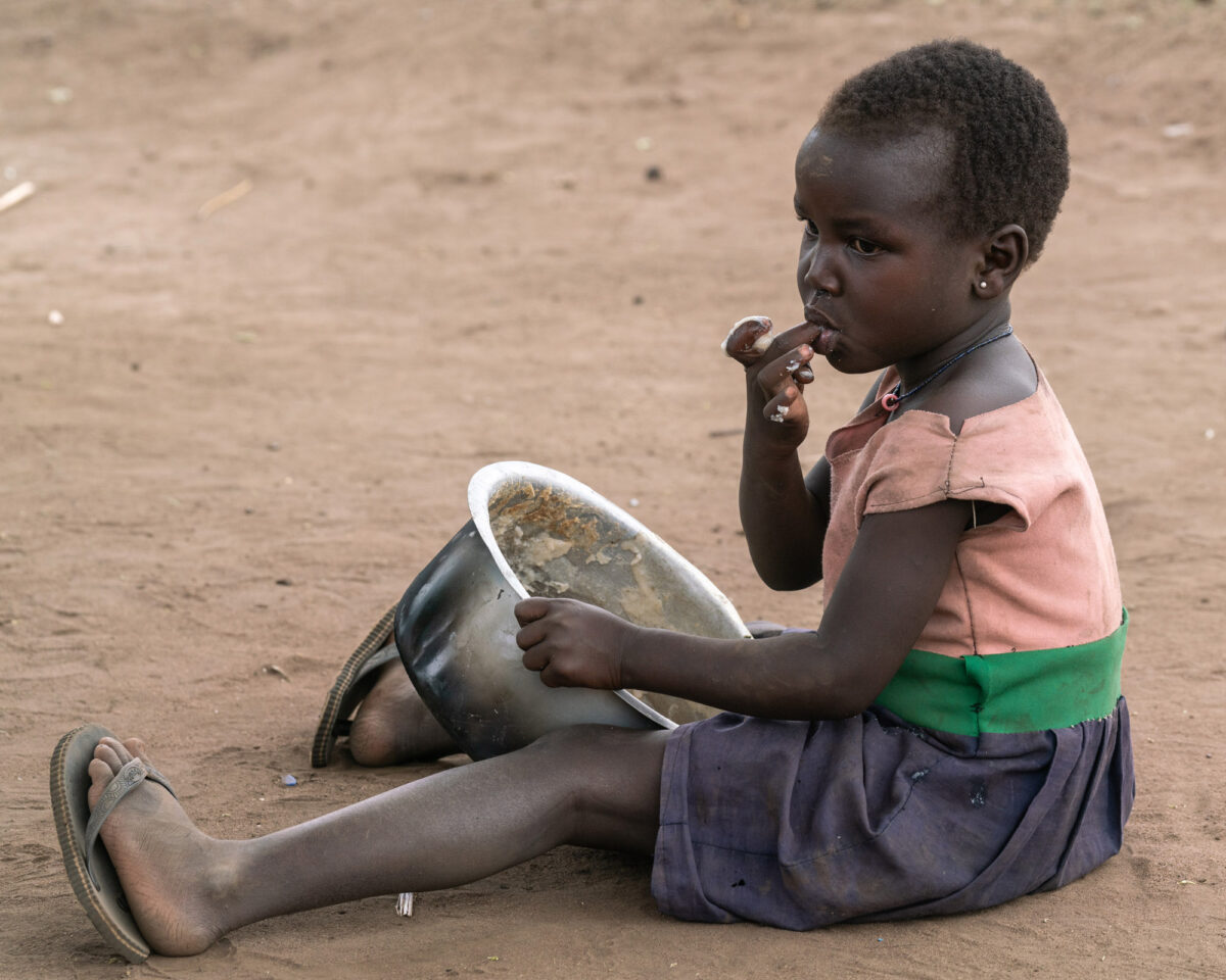 A child eating out of a pot