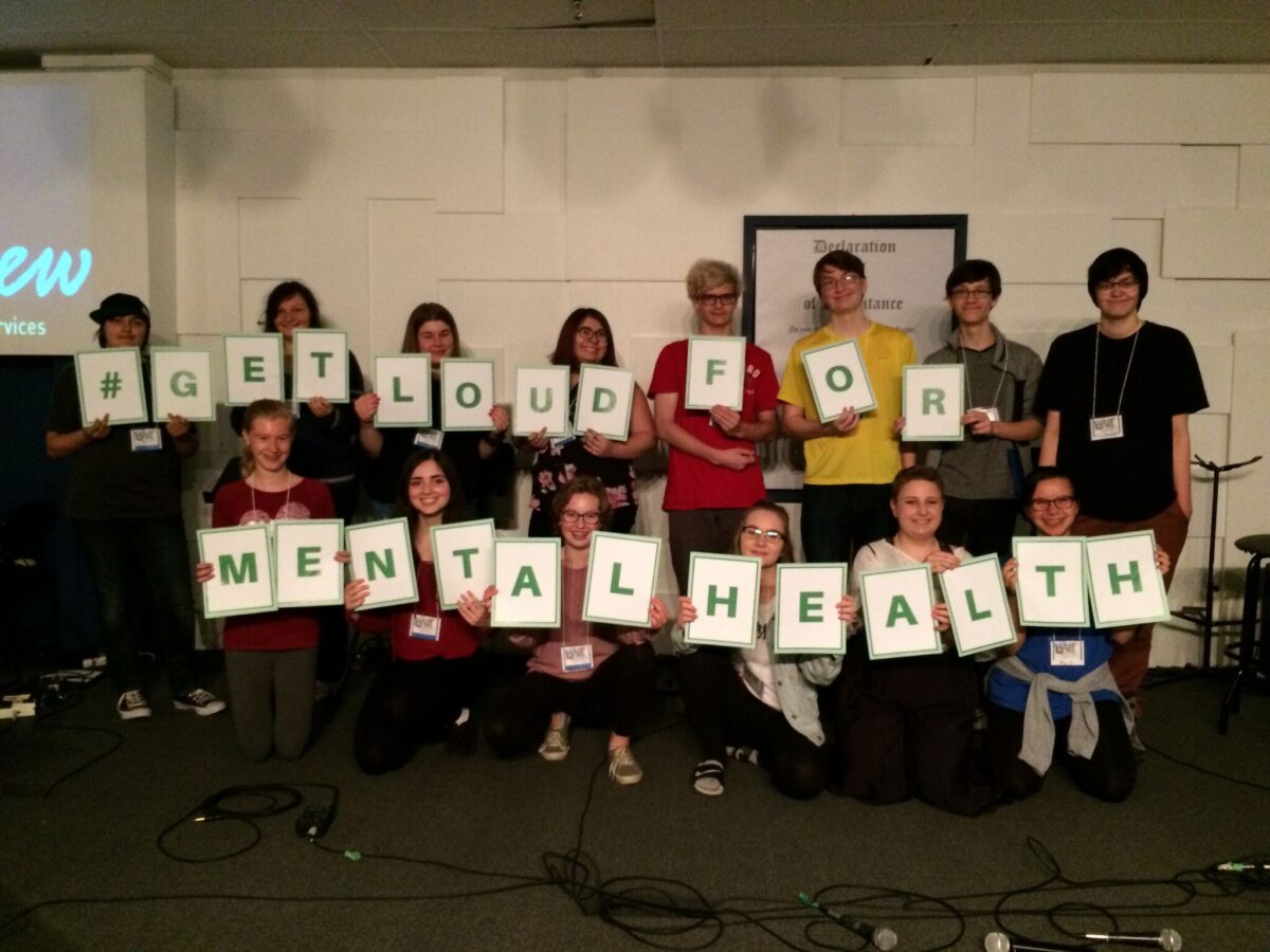 youth holding up letters spelling get loud for mental health