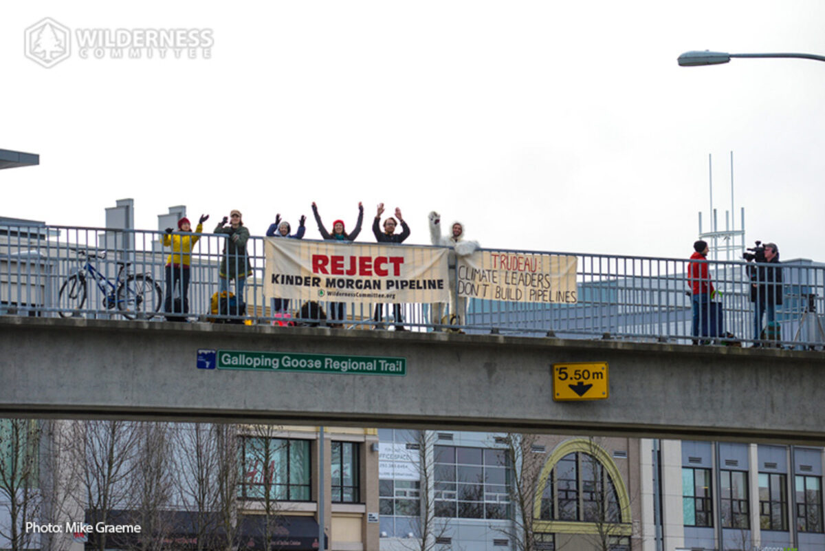 A group of people stand with a banner reading 
