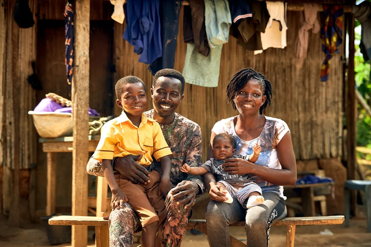 A family of four poses for a photograph in front of their home.