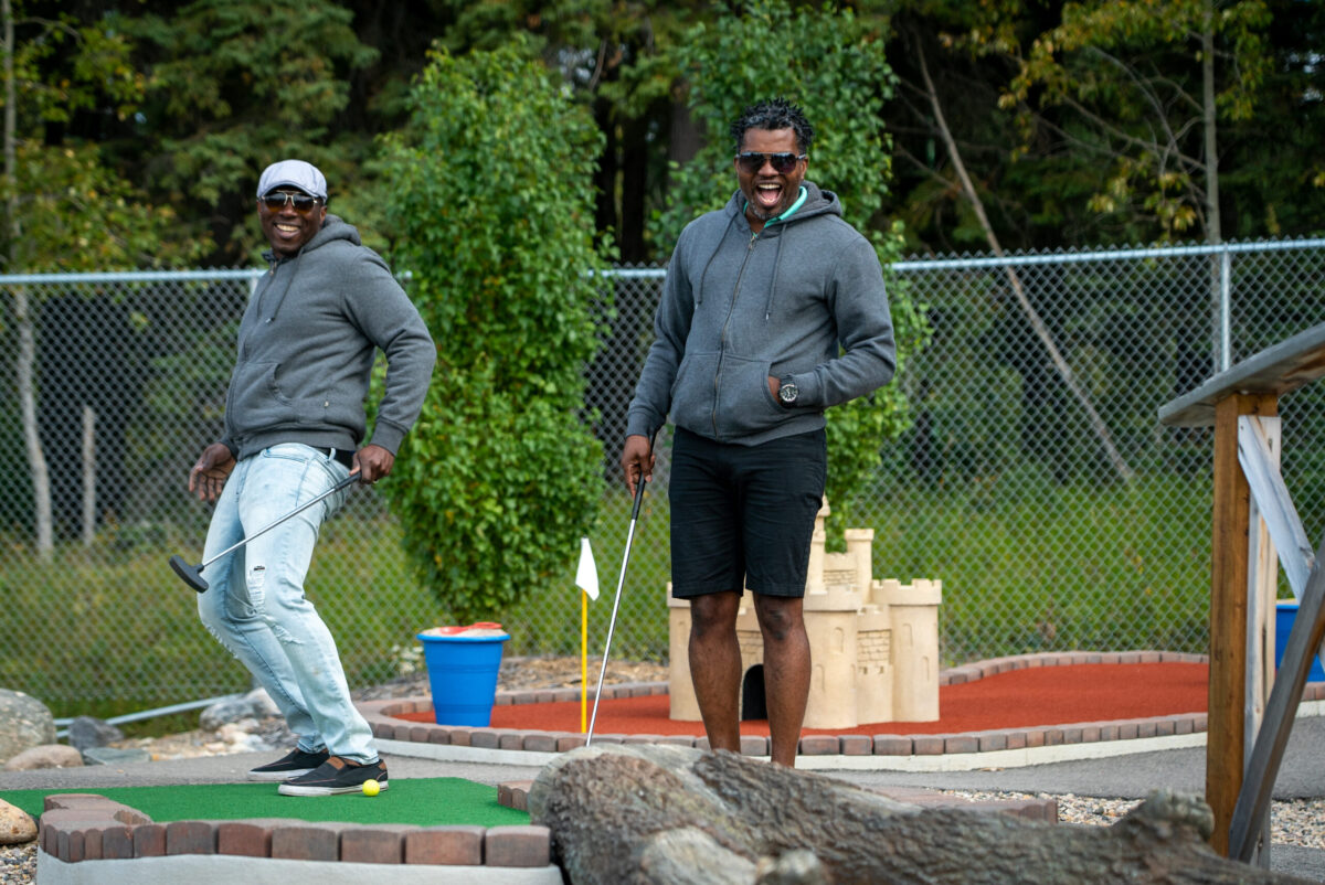 Two people celebrate a great putt at Little Al's Mini Golf at Waskesiu Lake