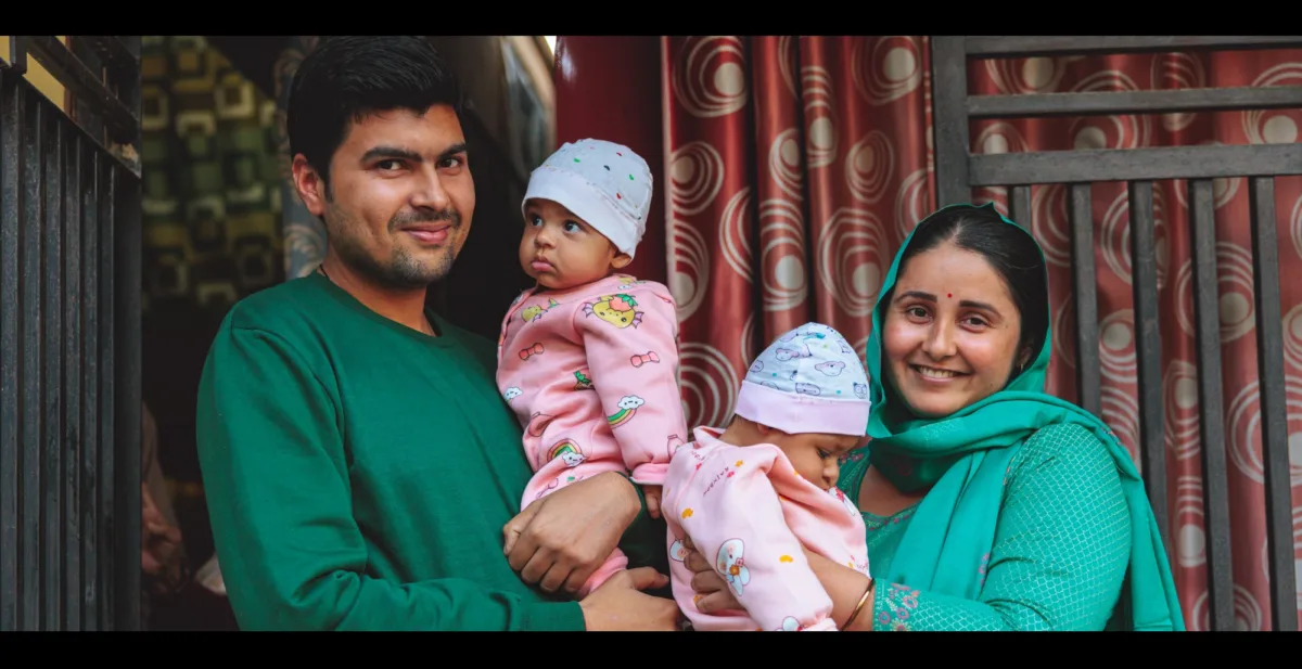 Video thumbnail shows young couple holding twin baby girls.