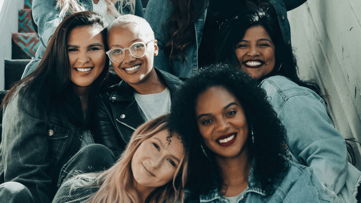 A group of women sitting and smiling.